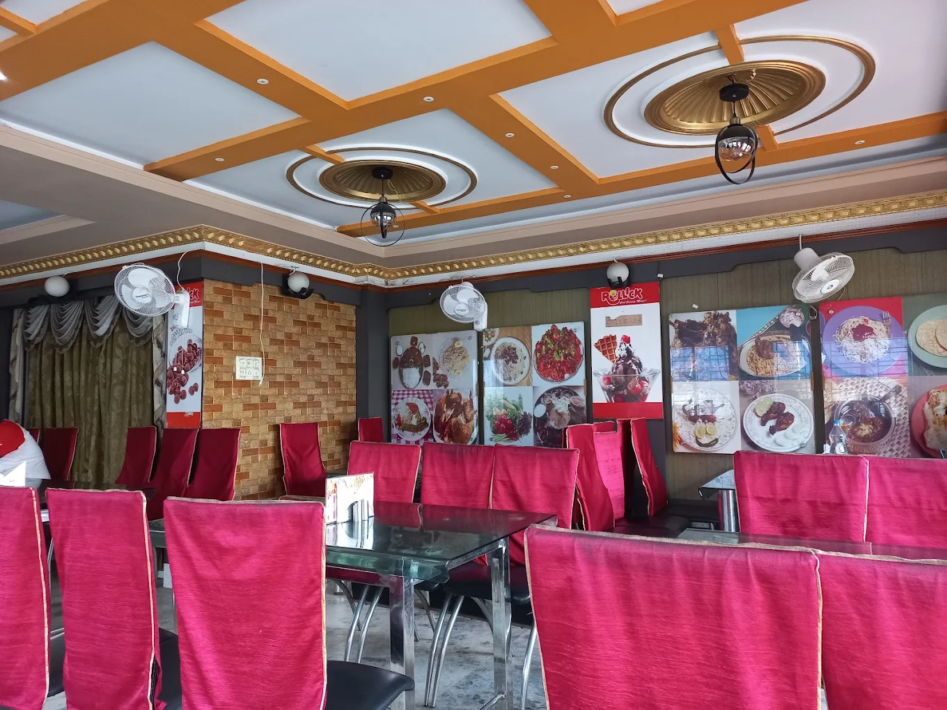 Interior seating with red chair covers and wall menu panels — bright daytime dining ambiance