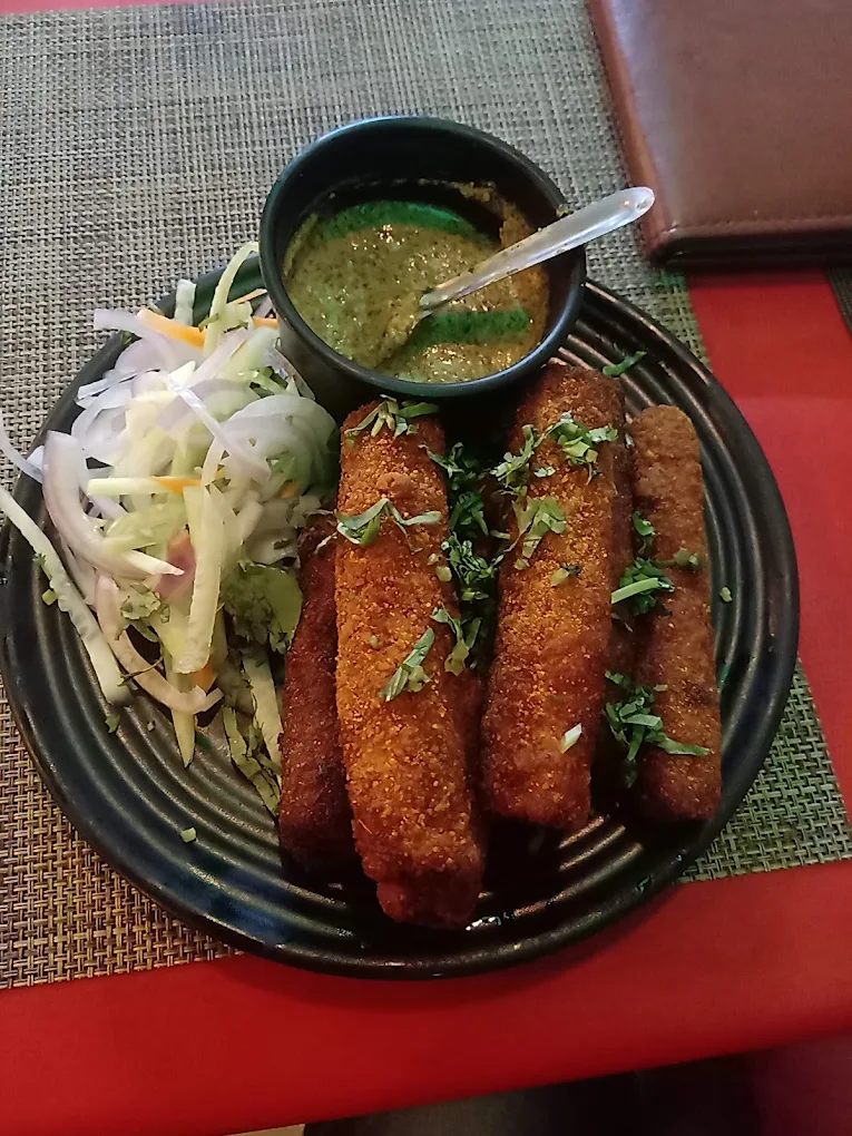 Crispy seekh-style kebabs served with green chutney and onion salad — a popular starter