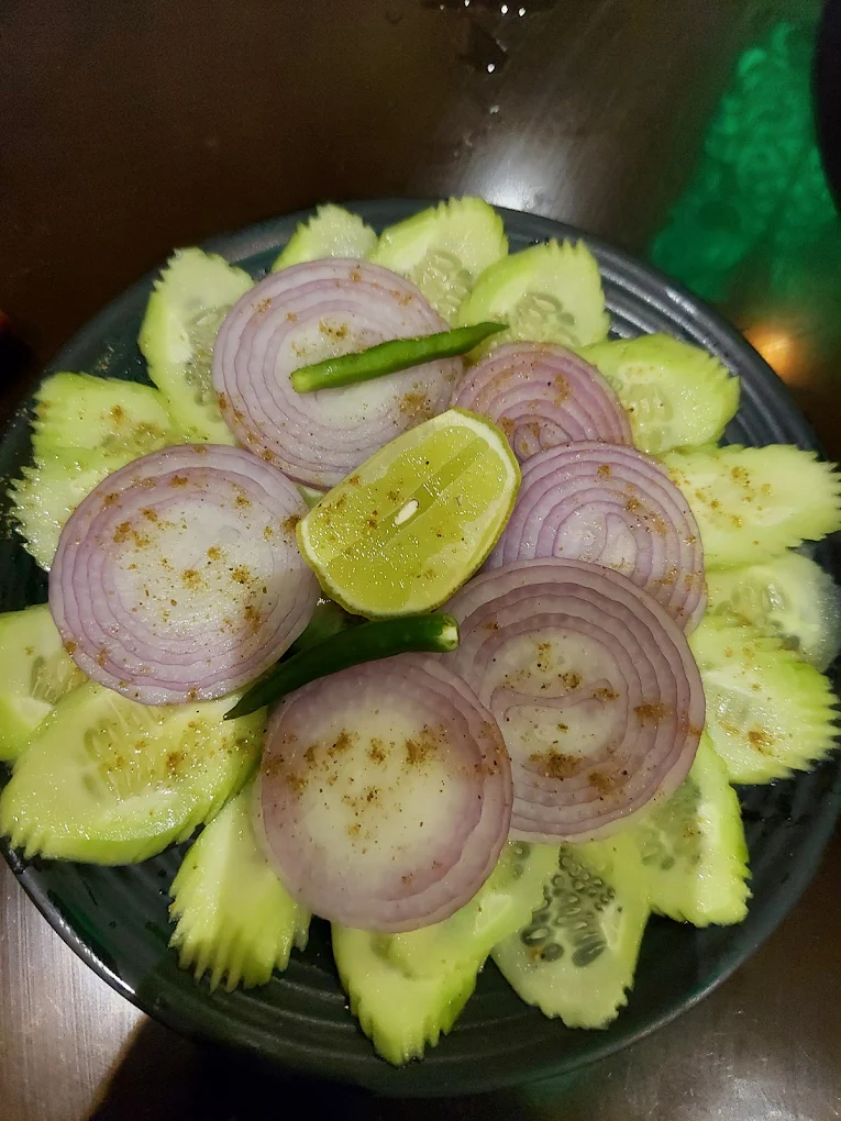 Fresh cucumber and onion salad garnished with lemon and green chillies — palate cleanser