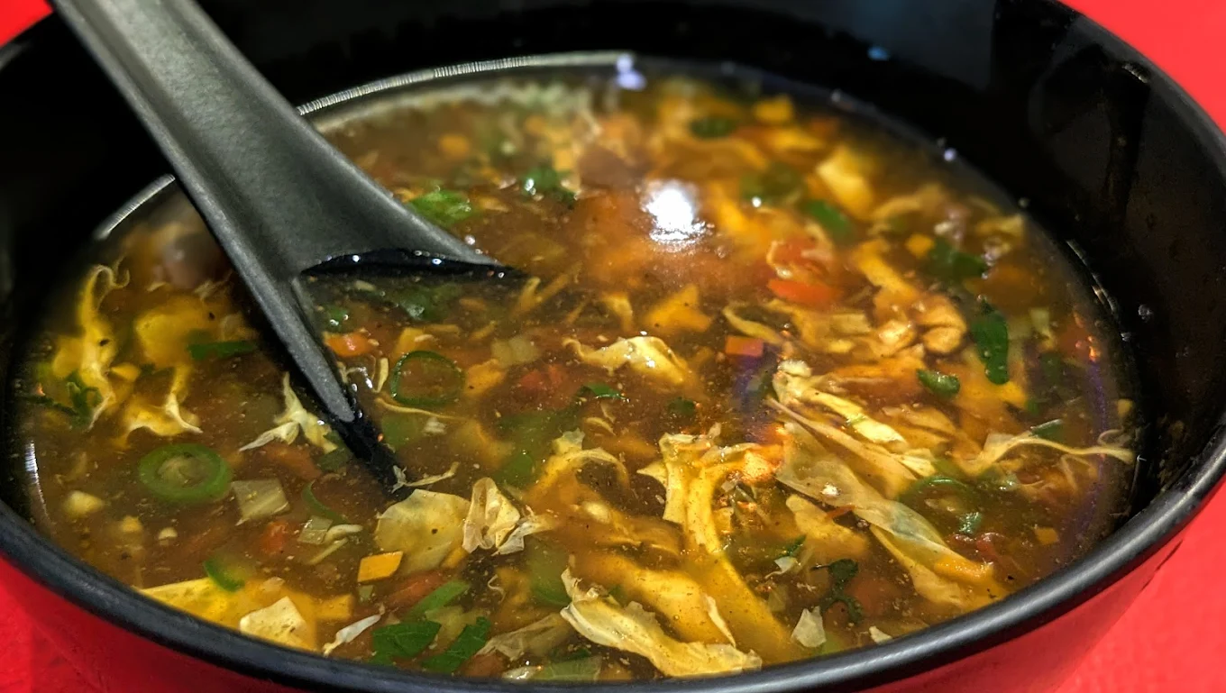Hot & sour style soup with shredded egg and vegetables — comforting soup bowl