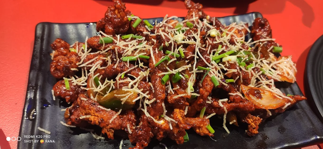 Signature Chilli Chicken garnished with fried sev and spring onions — crowd favorite (photo credit: Shot on Redmi K20 Pro by Rana)